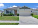 Inviting single-story home with a neatly kept lawn, a two-car garage and a welcoming front door at 401 Chayne Pl, St Cloud, FL 34771