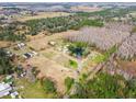 Aerial view of property showcasing buildings, pond, and surrounding landscape at 4771 Deen Still Rd, Polk City, FL 33868