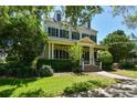 Two-story house with a wrap-around porch and manicured lawn at 510 Golfpark Dr, Celebration, FL 34747