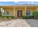 Inviting front entrance with a brick paver driveway and a stylish front door with glass panels at 663 Shorehaven Dr, Poinciana, FL 34759