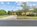 Well-maintained single-Gathering home with a lush front lawn, mature trees, and a brick driveway at 663 Shorehaven Dr, Poinciana, FL 34759