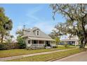 Charming two-story home with a welcoming front porch, complemented by mature trees and a well-maintained lawn at 723 New York Ave, St Cloud, FL 34769