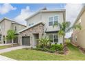 Modern two-story house with stone facade and landscaped front yard at 771 Drop Shot Dr, Davenport, FL 33896