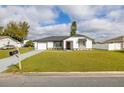 Charming single-story home with a well-manicured lawn, black roof, and inviting curb appeal at 83 Alameda Dr, Kissimmee, FL 34743