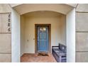 Inviting entryway with a gray door and bench at 8886 Geneve Ct, Kissimmee, FL 34747
