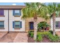 Townhouse exterior with blue shutters and palm trees at 8886 Geneve Ct, Kissimmee, FL 34747