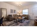 Comfortable living room featuring stylish decor, a modern chandelier, and lots of natural light at 8919 Shine Dr, Kissimmee, FL 34747