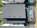 Top-down view of a house with a dark gray roof and a screened-in pool at 9234 Sommerset Hills Dr, Davenport, FL 33896