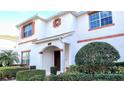 Delightful two-story townhouse features colorful shutters and accents, complemented by trimmed shrubs at 1596 Moon Valley Dr, Davenport, FL 33896