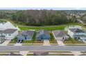 Aerial view of a house and neighborhood with a pond at 3027 Serendipity Way, Davenport, FL 33896