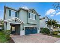 Charming two-story home featuring a brick driveway, teal shutters and a matching two-car garage door at 350 Pendant Ct, Kissimmee, FL 34747