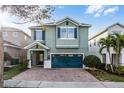 Charming two-story home featuring a brick driveway, teal shutters and a matching two-car garage door at 350 Pendant Ct, Kissimmee, FL 34747