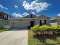 Front view of gray house with two-car garage and landscaping at 4310 Seven Canyons Dr, Kissimmee, FL 34746
