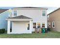 Backyard patio with covered space and a view of the well-maintained lawn and the house's rear exterior at 4571 Tribute Trl, Kissimmee, FL 34746