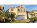 Two-story home with a large two-car garage, manicured lawn and paver driveway at 4571 Tribute Trl, Kissimmee, FL 34746