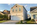 Two-story home with a two-car garage and a well-manicured lawn with paver driveway at 4571 Tribute Trl, Kissimmee, FL 34746