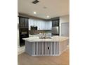Modern kitchen with two-toned cabinets, a large island, and stainless steel appliances at 626 Baldwin Dr, Kissimmee, FL 34758