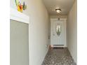 Front entry with tiled floor and a white door with glass accents at 6364 Domenico Ct, Groveland, FL 34736