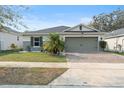 House exterior featuring a two-car garage and well-maintained landscaping at 6364 Domenico Ct, Groveland, FL 34736
