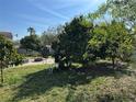 Spacious backyard with lush vegetation, fire pit, and a large grassy area at 780 Avenue H Ne, Winter Haven, FL 33881
