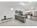 Open-concept kitchen with modern stainless steel refrigerator and gray cabinets at 7933 Merrimac Cove Dr, Orlando, FL 32822