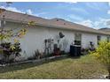 Back of the house with a satellite dish and AC unit at 813 Halifax Dr, Kissimmee, FL 34758