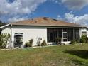 House exterior with a screened-in patio and lush plants at 813 Halifax Dr, Kissimmee, FL 34758