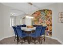 Elegant dining room with colorful art, contemporary chandelier, and seating for eight at 8939 Fallen Oak Dr, Davenport, FL 33896