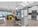 Open concept kitchen with modern island seating, stainless appliances, and a view of the living area at 8939 Fallen Oak Dr, Davenport, FL 33896