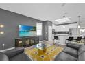 Open-concept living room and kitchen with modern decor and stainless steel appliances at 8939 Fallen Oak Dr, Davenport, FL 33896