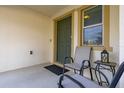 Covered front porch with seating and a charming entry door at 947 Emerald Green Ct, Kissimmee, FL 34746