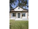 Home's charming front porch with natural wood columns and a modern front door at 0 Orangewood Ave, St Cloud, FL 34772