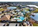 Aerial view of a community pool, waterslide, lakeside gazebo, lounge seating, and beautiful landscaping at 113 Kenny Blvd, Haines City, FL 33844