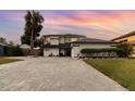 Charming two-story home with a well-manicured lawn, brick driveway, and a serene landscape with mature trees at 13008 Baltimore Woods Ln, Orlando, FL 32824