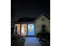 Night shot of a cozy home with a well-lit porch and blue accent front door along a brick walkway at 13432 Beebe Aly, Orlando, FL 32827