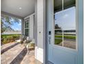 Inviting front porch with comfortable seating, views of a serene lake, and a stylish light blue front door at 13432 Beebe Aly, Orlando, FL 32827