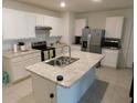 Modern kitchen features white cabinets, stainless steel appliances, and a central island at 1360 Berry Ln, Davenport, FL 33837