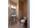 Cozy half-bathroom includes a pedestal sink and modern toilet at 14257 Desert Haven St # Ge, Windermere, FL 34786