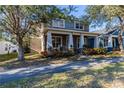 View of home showcasing charming architectural details, inviting front porch, and mature trees at 14637 Tanja King Blvd, Orlando, FL 32828