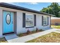 Close up of the exterior showing a light blue home, black shutters, and dark trim at 152 Harrison St, Lake Wales, FL 33859