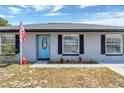 Close-up of a well maintained single-story home with a bright blue front door at 152 Harrison St, Lake Wales, FL 33859