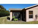 Exterior view of the home with a screened in lanai, window, and greenery at 156 Grand Canal Dr, Poinciana, FL 34759