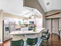 Modern kitchen featuring stainless steel appliances, granite countertops, stylish barstool seating, and ample cabinet space at 206 Memphis Pl, St Cloud, FL 34769