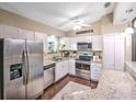Bright kitchen featuring stainless steel appliances, granite countertops, stylish barstool seating, and ample cabinet space at 206 Memphis Pl, St Cloud, FL 34769