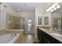 Main bathroom with granite countertops, soaking tub, and walk-in shower at 2112 Morocco Way, Kissimmee, FL 34747