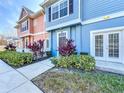 Inviting townhome with colorful facade, showcasing lush landscaping, a tidy sidewalk, and charming curb appeal at 2203 San Vittorino Cir # 107, Kissimmee, FL 34741