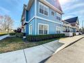 Beautifully landscaped townhome with a blue exterior, featuring a well-maintained lawn and inviting sidewalk at 2203 San Vittorino Cir # 107, Kissimmee, FL 34741