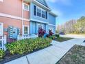 Charming townhome showcases its colorful exterior, complemented by vibrant landscaping and a welcoming sidewalk at 2203 San Vittorino Cir # 107, Kissimmee, FL 34741