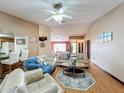 Spacious living area with wood floors, comfortable furniture, vaulted ceiling, and views into dining area at 3039 China Berry Ct, Kissimmee, FL 34746