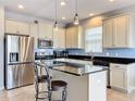 Modern kitchen with stainless steel appliances, granite countertops, and center island with bar stool seating at 3857 San Isidro Cir, St Cloud, FL 34772